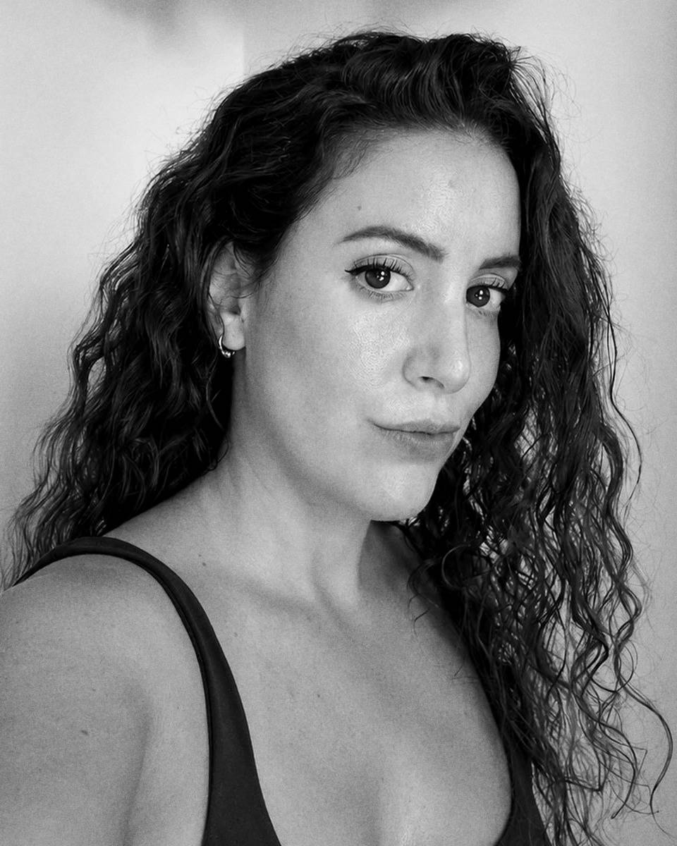Portrait en noir et blanc d'une jeune femme aux cheveux bouclés.